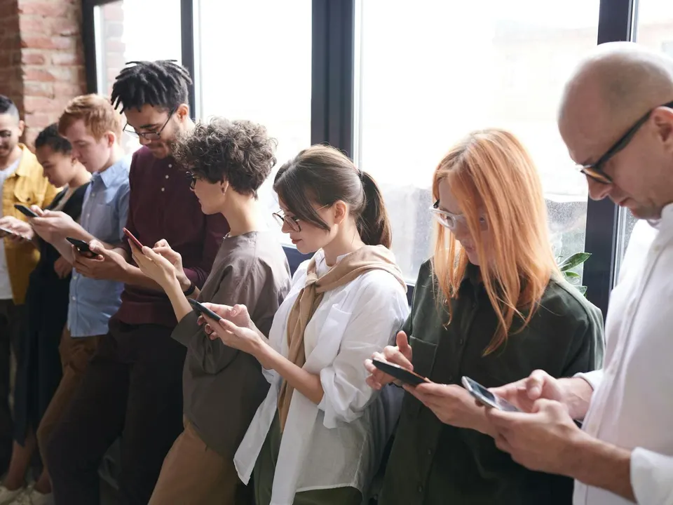 Menschen schauen gemeinsam auf ihre Smartphones